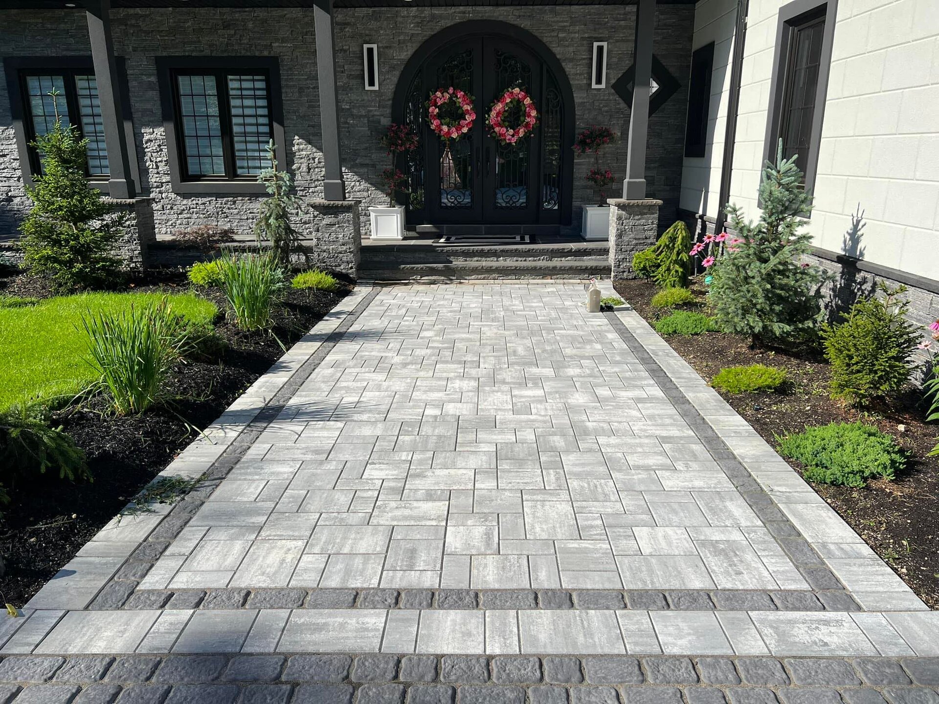 Premium paver walkway with elegant arched entryway by KONOP Quality Contracting